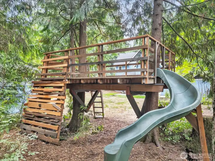 The back side of the Tree Fort with a climbing wall and slide. Great for small people, but it can accommodate adults for a unique dinner spot, if you'd like.