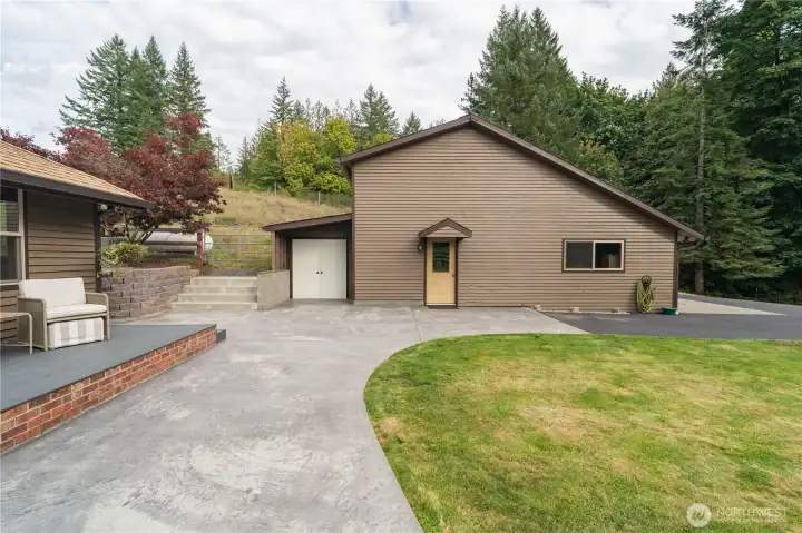 Front deck & patio leading towards the side entrance of the garage & separate storage space for all your lawn equipment, or even a cold storage/canning room opportunity!