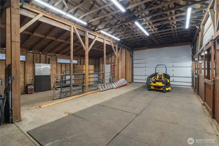 Interior of barn with plenty of room for horse trailer parking, hay storage, and even the ability to add more stalls!
