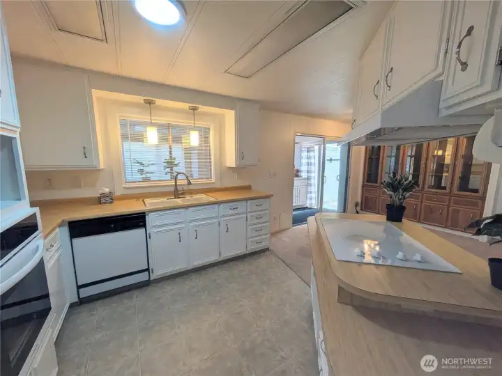 Kitchen has been updated from original. design. Lots of cabinets and lighting. Plenty of room for a dining table if desired by the built-in china cabinet.