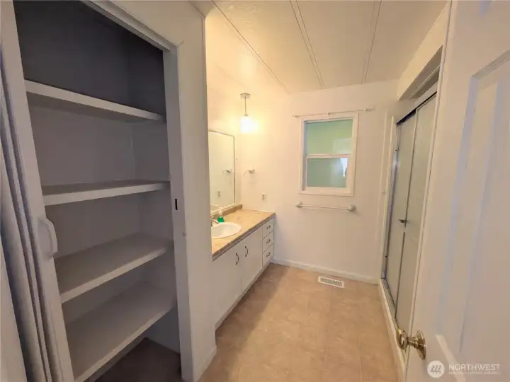 Primary bathroom with a large linen closet. Commode is behind the door.