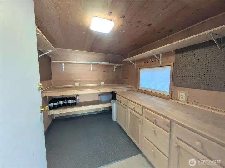 This shed is at the end of the carport and is beautifully finished! Functional work bench and ample cabinetry.