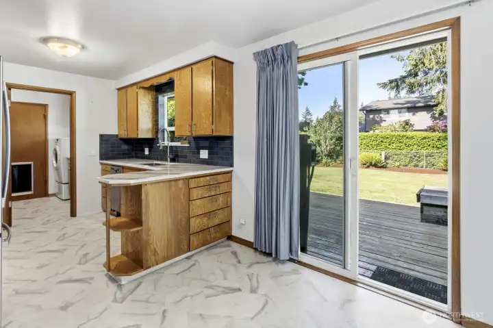 View of the kitchen from the dinning area and laundry room in the distance with a door leading to the garage