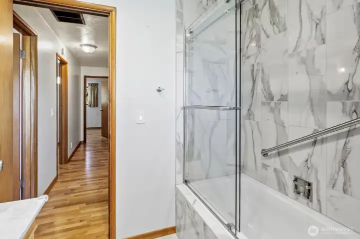beautiful shower with shower doors and grab bar