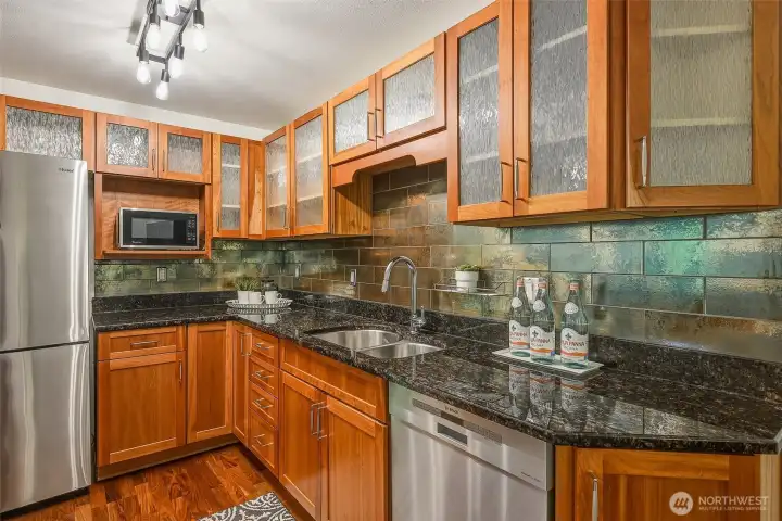 Well-appointed kitchen features slab granite counters, tiled backsplash, deep double sink, and Bosch dishwasher Well-appointed kitchen features slab granite counters, tiled backsplash, deep double sink, and Bosch dishwasher