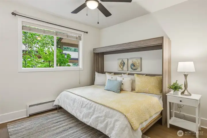 Guest bedroom with Murphy bed offers flexible space for overnight guests, a home office, or both. Bed and mounted TV (not in picture) convey Guest bedroom with Murphy bed offers flexible space for overnight guests, a home office, or both. Bed and mounted TV (not in picture) convey