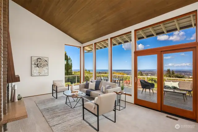 Living Room with panoramic views, cedar ceiling, architectural wood burning fireplace and wood slider makes for seamless entertaining inside and out.