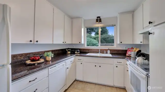 Light & bright kitchen with kitchen window looking out to the front yard.