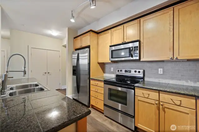 Kitchen with stone counters & full appliance package stays.