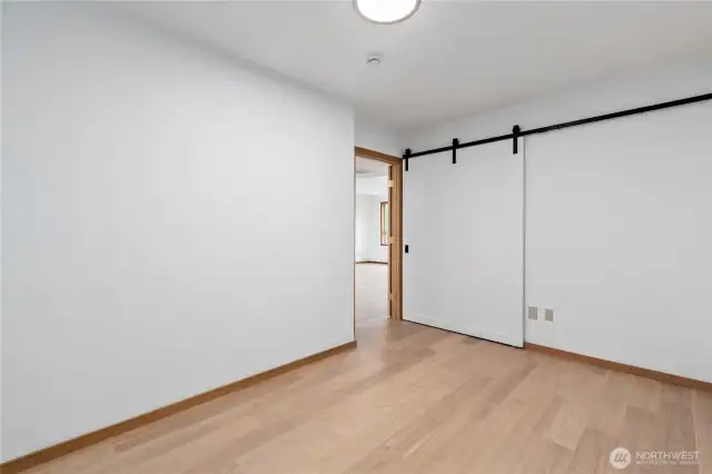 Custom barn door opens to a closet, storage area.