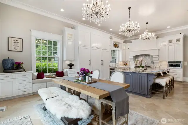 The kitchen is as much about ambiance as it is about function. Three Restoration Hardware crystal chandeliers add sparkle and charm, with dimmable lighting to set the perfect tone for lively gatherings or intimate dinners. A cozy window seat overlooking a bed of lush blue hydrangeas invites guests to linger with a glass of lemonade or a morning cup of coffee.