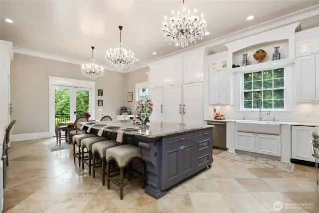 At the center of it all sits a stunning Shaws Lancaster 39.5” apron-front farmhouse sink, crafted in England, complete with Waterstone USA Rohl artisan fixtures, including a chrome pot filler, built-in soap dispenser, instant hot water tap, and hand sprayer. A trash compactor and built-in recycling bin make cleanup effortless. Surrounding the kitchen is a mix of diamond white quartzite countertops and a sprawling Cabernet quartz dining island—which comfortably seats four and includes an in-island sink for prepping fresh    vegetables from the garden. The island also boasts two Rev-a-Shelf appliance lifts, perfect for concealing a stand mixer or slow cooker, along with hidden outlets for added utility.