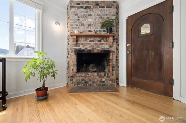 An amazing solid from door with a vintage window insert opening.  Receive your guest through this lovely door into the bright living room with a lovely brick wood burning fireplace.