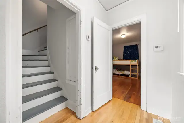 Stairway leading to the upper floor where there is a full bathroom and two additional bedrooms.