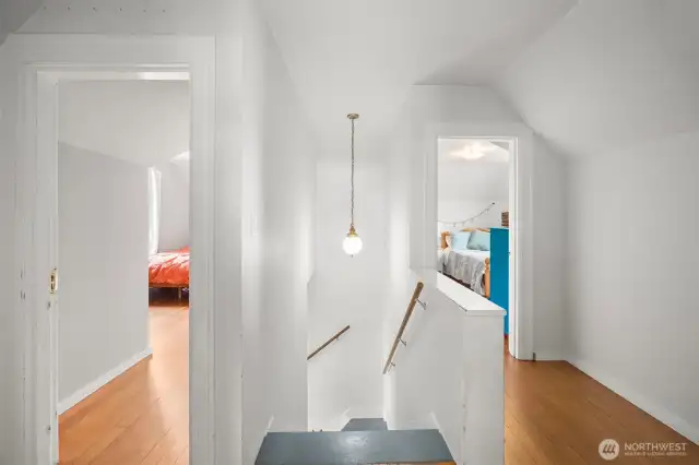 Upper level landing at the top of the stairs shows the bedroom to the right and to the left. Behind is the full bathroom and a storage cubby.