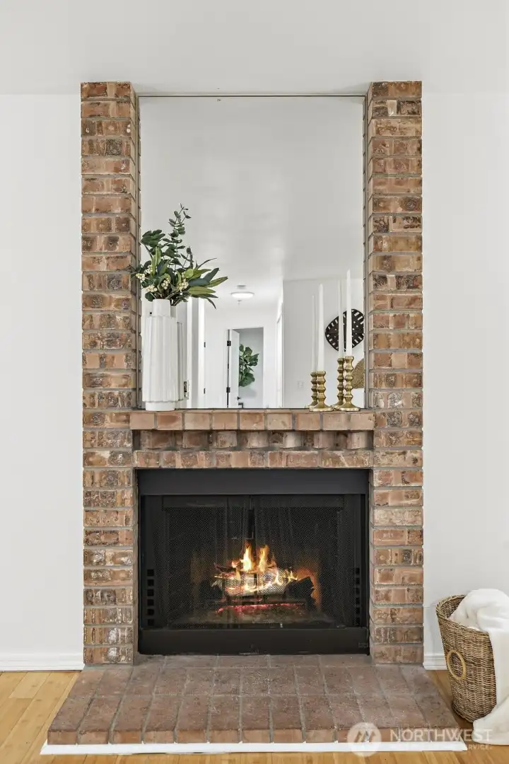 Full-height brick fireplace with mirror surround and mantel — a warm, standout feature in the living space.