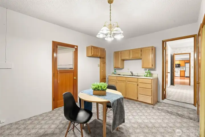 There’s already a sink here, which adds to the flexibility of the space, and the wood door serves as a back entrance that leads directly outside.
