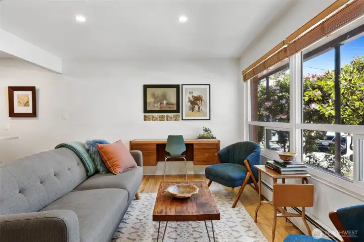 Original hardwood floors gleam in fantastic afternoon light beaming in through large windows.
