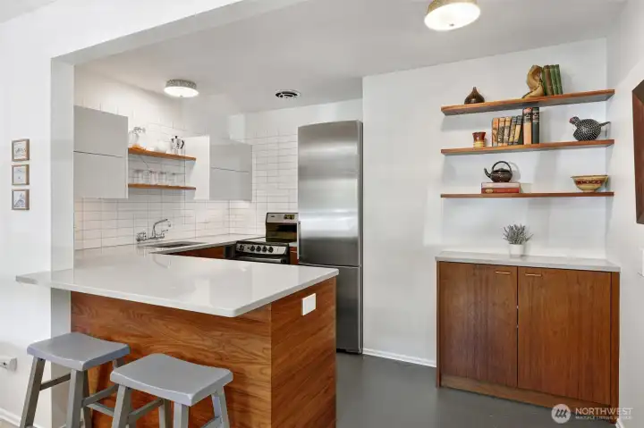 Large peninsula for hosting/dining, just enough open shelving for flair, custom walnut cabinetry, and eco-friendly & soft marmoleum under foot.