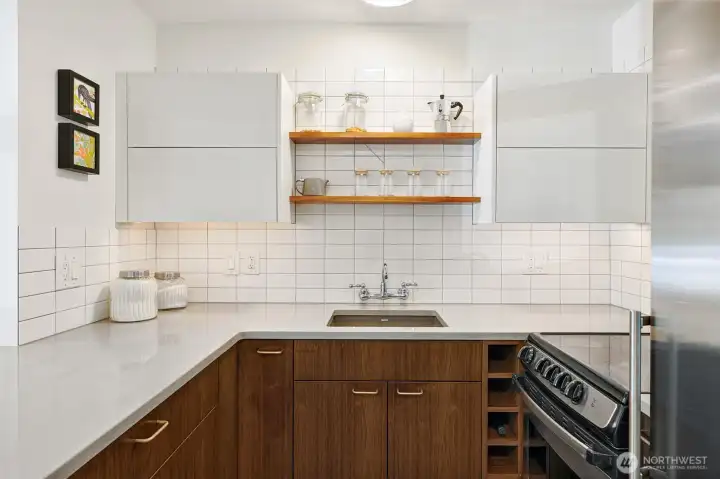 Everything is within the chef's reach; you'll love to cook in this efficient, stylish space with wine storage, pull-out spice rack, counter-depth fridge, and Aventos lift upper cabinet doors.