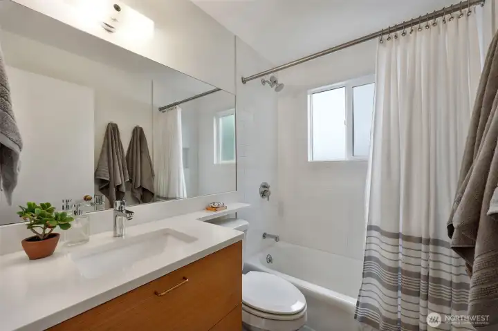 Updated full bathroom includes a custom oak vanity with large storage drawers, plus radiant in-floor heat!