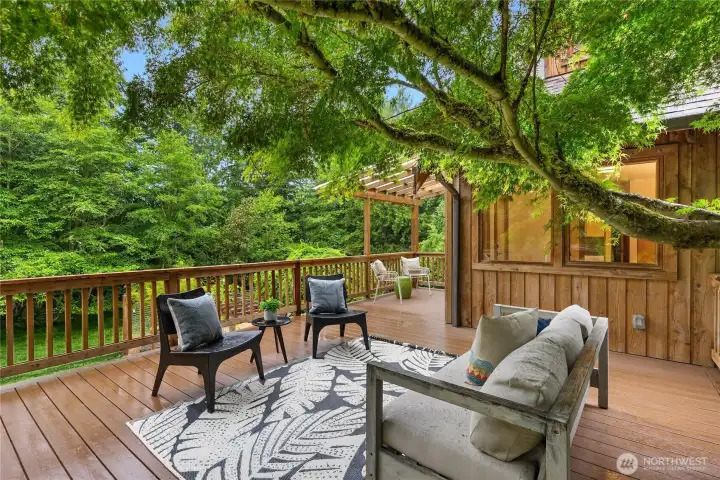 Expansive entertaining deck nestled among the trees, offering peaceful outdoor living and year-round privacy.