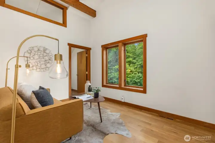 Bright flex room with vaulted ceilings and garden views.