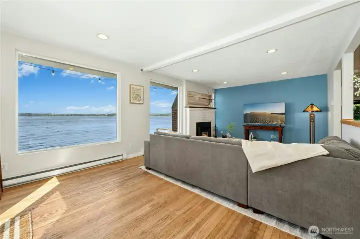 Sunlight pours through expansive picture windows, framing captivating Puget Sound views.