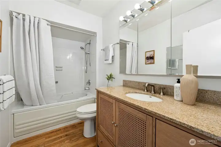 Updated hardware and cabinetry bring thoughtful touches to this full bathroom.