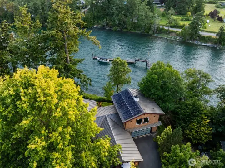 A roof-mounted SunPower solar system installed on the amin house and detached garage provides meaningful supplemental power for the property, with Enphase microinverter technology and no battery storage. The approved plans reference a 14.04 kW system with estimated first-year production of approximately 14,842 kWh.
