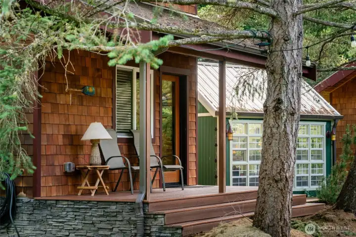 A cedar-sided guest cabin sits quietly along the edge of the pond, offering a warm and private retreat immersed in the landscape. With water, evergreens, and soft reflections just outside, it feels both tucked away and deeply connected to the property’s natural setting.