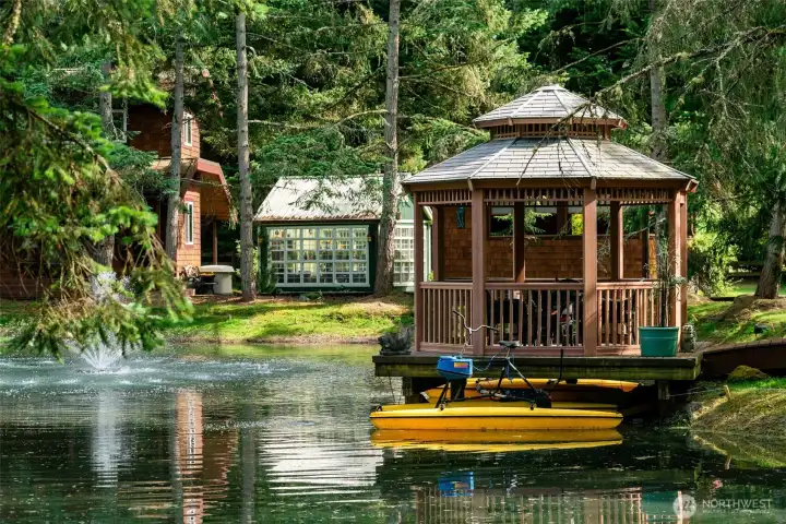 The private pond adds another layer of recreation and calm, with a fountain, waterside gazebo, and small boats inviting easy afternoons on the water. Whether paddling, relaxing dockside, or gathering at sunset, it creates a playful and restorative retreat within the property.