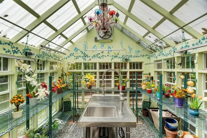 The greenhouse is a bright, whimsical garden workspace, filled with natural light, planting benches, and thoughtful details for tending flowers, herbs, and seasonal starts. With its vaulted translucent roof and surrounding windows, it feels both practical and enchanting — a place for cultivation, creativity, and quiet retreat.