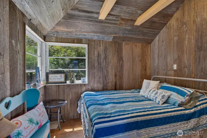 The first bedroom offers a vaulted wood ceiling, rustic charm, and a cozy space.