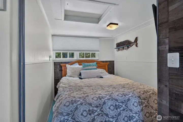 Cozy second bedroom featuring built-in loft storage above.