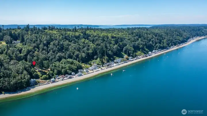 Nestled among the trees on an oversized waterfront lot, this coastal retreat offers privacy, panoramic views, and direct beach access.