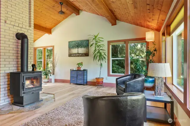 Inside the home, you'll find this beautifully vaulted ceiling within this intimate space that is open area living room, dining & kitchen. Cozy new wood-burning fireplace, new windows and vinyl plank flooring.