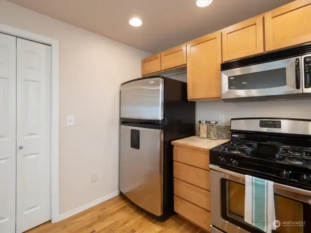 Spacious kitchen with a pantry closet, breakfast bar, and gas range. Photo shows Unit B (MLS 2276317) with reversed identical floor plan.