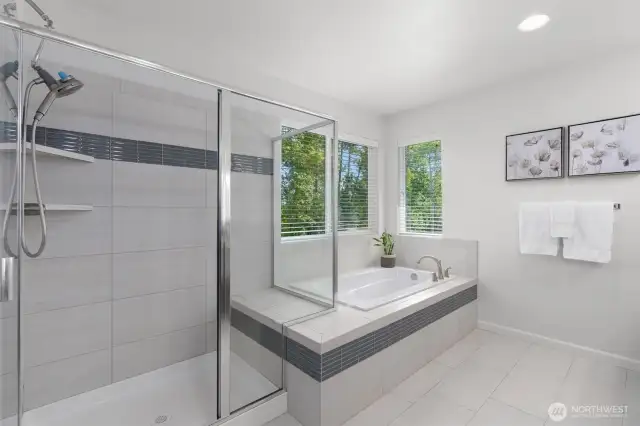 Unwind in the spa-inspired elegance of this luxurious primary bathroom, featuring a large soaking tub with tranquil tree-lined river views and a separate glass-enclosed walk-in shower. Sleek tile-work, modern fixtures, and abundant natural light create a serene and sophisticated retreat!