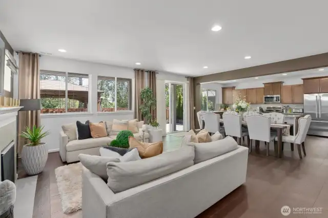 Bathed in natural light from large windows and sliding glass doors, the space flows seamlessly from the cozy living room with fireplace to the spacious dining area and gourmet kitchen.