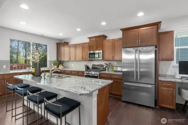 The expansive center island offers ample prep space, seating for four, and an under-mount sink including a filtered alkaline drinking water faucet - perfect for hosting guests or enjoying casual meals.