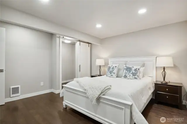 Lower-level primary suite with barn door storage closet