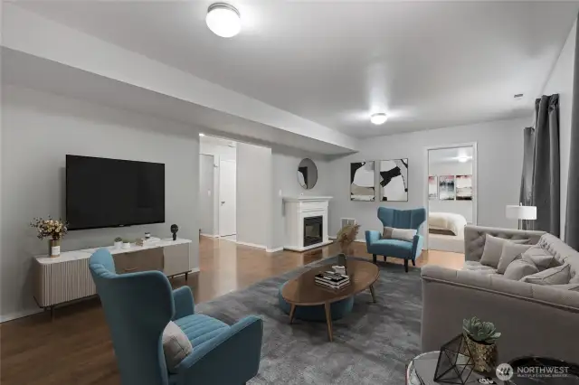 Downstairs living room is warm and cozy with electric fireplace. Virtually staged.