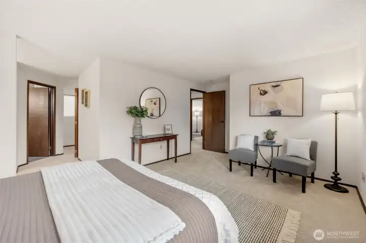 The Primary Suite features new carpet, a spacious layout with room for a seating area, and direct access to the en-suite bath. A functional flow and neutral palette create a comfortable retreat.