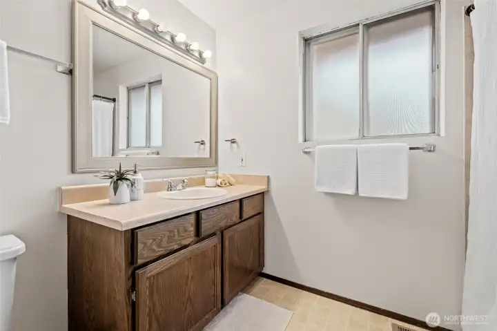 Conveniently located near the additional bedrooms, this full bathroom features ample counter space, plenty of storage, and privacy window—ideal for daily use or accommodating guests with ease.