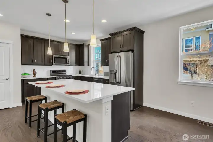 Kitchen features island with large eating bar and storage