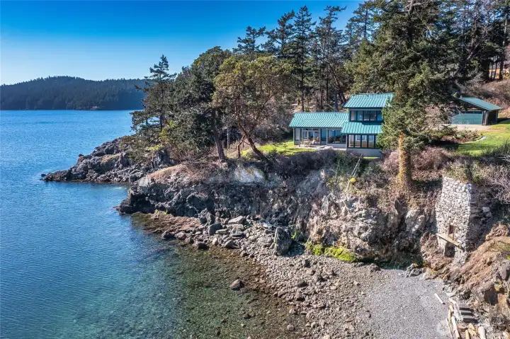 This photo shows the historical Lime Kiln located to the north of the main home, built on the bank above the beach. The property has ownership of a portion of this beach adn tidelands.