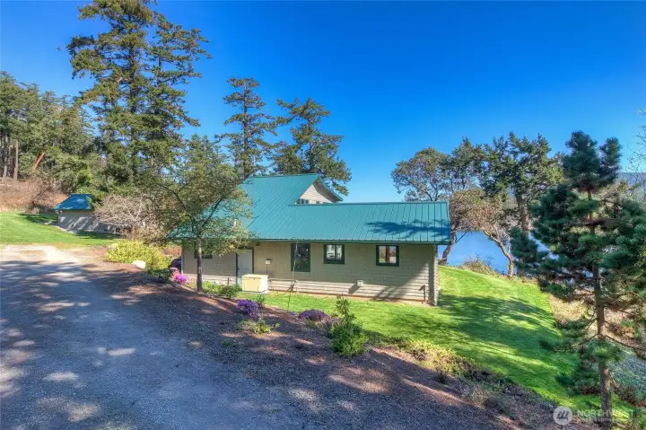 Driveway into the property. South side of main home with guest house in the background.