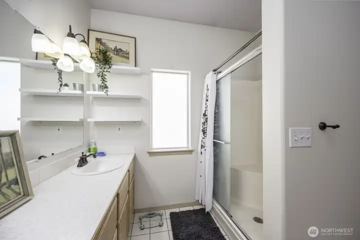 3/4 ensuite bath featuring stand up shower and ceramic tile flooring
