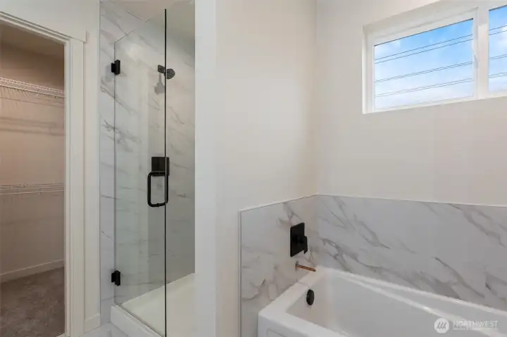 Shower in Primary Bathroom has floor to ceiling tile.